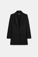 Blazer largo de corte entallado con cuello de solapa, manga larga y cierre frontal con dos botones. Presenta bolsillos de vivo en la parte delantera.