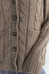 Cardigan de tejido de punto con diseño de ochos, escote en V, cierre frontal con botones y bolsillos delanteros. Presenta una silueta relajada y mangas largas.