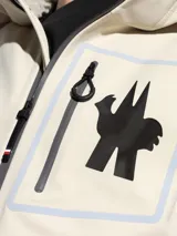 Chaqueta con capucha Moncler modelo Cormet color beige con cierre frontal con cremallera, bolsillos laterales con cremallera y logo de la marca en el pecho.