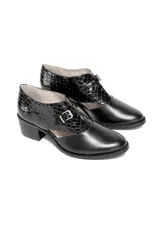 Zapato de tacón cuadrado color negro, confeccionado en cuero con combinación de texturas: efecto reptil en la parte trasera y cuero liso en la puntera. Presenta un diseño con aberturas laterales y cierre con hebilla dorada.