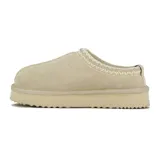 Pantufla tipo mule de cuero gamuzado color beige, con detalle de costura decorativa en el borde superior y suela de plataforma plana con base dentada.