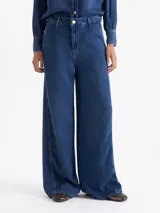 Pantalón wide leg de tiro alto color azul, confeccionado en tencel. Presenta metales dorados como detalles, bolsillos diagonales en el frente y bolsillos ojal en la espalda.