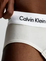 Pack de tres slips de algodón elástico color azul con cintura elástica blanca con logo de Calvin Klein. Corte hip brief.