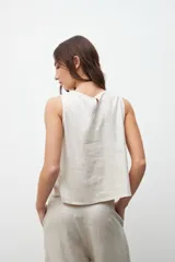 Top sin mangas de corte recto y holgado, con cuello redondo, confeccionado en tejido con acabado laminado plateado.