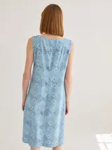 Vestido midi sin mangas con cuello en V, confeccionado en tela estampada con diseño gráfico de letras entrelazadas. Presenta un corte recto y holgado.