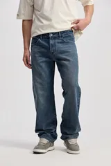 Pantalón jean de corte recto y amplio, color azul con efecto lavado y desgaste sutil.