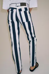 Jeans de tiro medio de corte slim, con diseño de rayas verticales a contraste en color azul marino y blanco. Cuenta con cinco bolsillos, trabillas para cinturón y cierre frontal con cremallera y botón metálico.