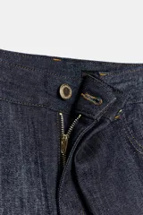 Jeans de tiro medio, pierna relajada y largo completo, color azul oscuro. Presenta cinco bolsillos, detalle de pliegue delantero y pespuntes marcados a contraste.