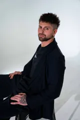 Blazer de lycra color negro, de corte oversize y diseño estructurado con solapas clásicas. Presenta detalles bordados sutiles en la solapa y en el puño de la manga.