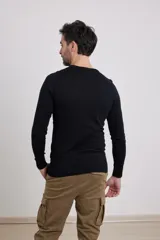 Sweater de punto liso, color azul, con escote redondo y manga larga.