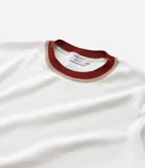 Remera regular de algodón blanca con cuello redondo y mangas cortas con ribete rojo.