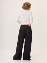 Pantalon ancho de denim en varios tonos de azul con diseño patchwork, de tiro medio y cierre frontal con botones.