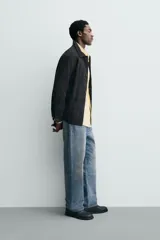 Sobrecamisa de ante color negro, con corte relaxed fit, cuello solapa, manga larga con puño abotonado, bolsillos de plastrón en la cadera y cierre frontal con botones.