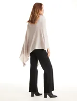 Poncho tejido de punto con diseño asimétrico y aberturas laterales para los brazos.