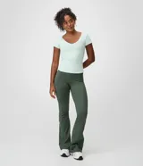 Pantalón flare deportivo Get Over de color verde oscuro, confeccionado en microfibra con cintura alta, pretina ancha, calce ajustado y vivos frontales.