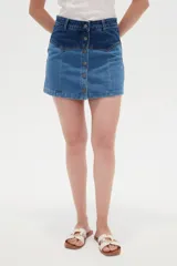 Minifalda de denim con diseño color block que combina dos tonos de azul, tiro alto y cierre frontal con hilera de botones metálicos.