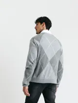 Sweater de punto con diseño de rombos en gris y azul marino, escote redondo a la base, manga larga y terminaciones en punto acanalado en cuello, puños y ruedo.