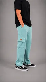 Pantalón tipo jogger cargo de corte holgado, color turquesa, con bolsillos laterales tipo cargo y parche decorativo en el bolsillo.