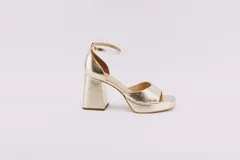 Sandalias de cuero color dorado con plataforma, tacón cuadrado y pulsera al tobillo.