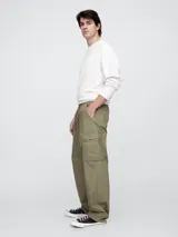 Pantalón cargo de corte holgado, confeccionado en popelina color beige, con cintura elástica ajustable mediante cordón y bolsillos laterales tipo cargo.