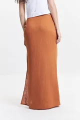 Falda larga negra de calce recto con tajo lateral alto y detalle fruncido en un lateral de la cintura.