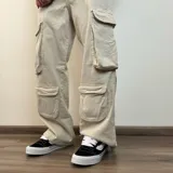 Pantalón de jean estilo cargo con corte baggy, color azul lavado. Presenta cuatro bolsillos laterales de gran tamaño con solapa y cierre de botones, diseño de pierna ancha y tiro medio.