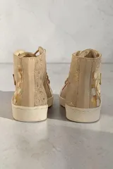 Botas de caña alta de cuero vacuno en color beige con brillos suaves y detalles pintados a mano por Carolina De Cunto, con cordones y suela de goma.