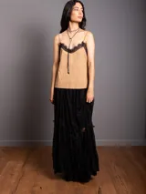 Top de breteles finos estilo camisola, confeccionado en material símil gamuza color negro, con detalle de encaje en el escote y costura vertical frontal.