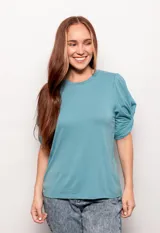 Remera celeste de manga corta con detalle de nudo en las mangas y cuello redondo.