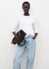 Jeans tiro medio color celeste, de diseño recto y largo, con bajo vuelto, trabillas, cierre de botón y cremallera, estilo cinco bolsillos y detalle de costuras verticales.