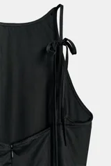 Vestido midi negro con cuello halter y falda acampanada con volumen.