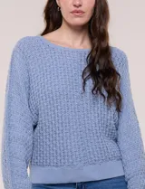 Buzo de algodón blanco con diseño de punto calado y mangas anchas.