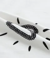 Blusa de algodón blanca con cuello redondo y manga corta abullonada. Estampa con corazones, copas y texto.