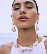 Collar maxi con cordón torcido y colgantes grandes de caracola con detalles dorados.