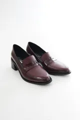 Mocasines Emilia de cuero vacuno en color bordó, con diseño de punta almendrada, detalle de antifaz con textura texturizada en la parte superior y tacón de bloque ancho en color negro.