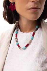 Collar corto compuesto por una combinación de cuentas de piedras naturales, cristales checos y cuentas reconstituidas en tonos rojos, turquesas y grises, con cierre de cadena de acero quirúrgico ajustable.