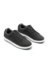 Zapatilla urbana de caña baja, color blanco, con cordones blancos. Presenta paneles laterales con perforaciones y un detalle de refuerzo en el talón de color negro.