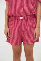 Short rosado de algodón con diseño a rayas verticales y cintura elástica, con etiqueta frontal de la marca Aire.