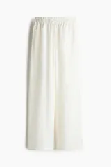 Pantalón de corte holgado en tejido liviano de mezcla de lino. Modelo de tiro alto con cintura elástica y cordón para ajustar fino, bolsillos laterales discretos y piernas rectas.