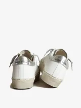 Zapatillas Golden Goose modelo Hi Star, color blanco con estrella plateada y detalles en animal print. Plataforma con texto estampado.