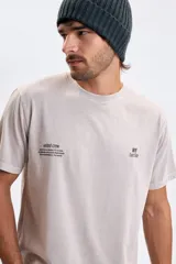 Remera de manga corta con efecto lavado, color gris claro, con estampado tipográfico minimalista en el pecho.