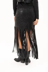 Pollera midi de cuerina negra con diseño ajustado en la parte superior y terminación en flecos largos que aportan movimiento.