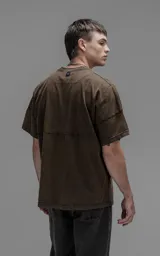Remera de manga corta con calce extra oversize, confeccionada en jersey 24/1 americano con efecto teñido o lavado que simula óxido o desgaste. Presenta un recorte horizontal en el torso delantero y trasero.