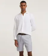 Bermuda de hombre en lino color gris claro, de corte recto, con textura discreta, bolsillos laterales y cierre frontal con botón y cremallera.