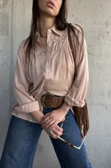 Camisa de manga larga color rosa viejo con detalles bordados florales en el canesú delantero y botones frontales.