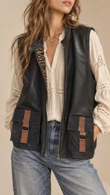 Chaleco de cuero sintético color negro, con cuello alto, cierre frontal y bolsillos frontales con solapa y detalles en cuero marrón. Posee forrería con estampado animal print.