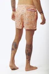 Short de baño salmón con estampado de tablas de surf, cordón ajustable en la cintura y etiqueta lateral de la marca.