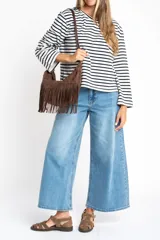 Remera de manga larga con cuello redondo, corte ajustado al cuerpo y patrón de rayas horizontales anchas en blanco y azul marino.