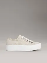 Zapatillas de plataforma Calvin Klein con diseño de jacquard monograma en tonos beige, suela blanca gruesa y cordones blancos.