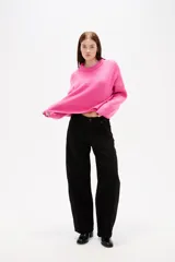 Sweater de tejido de punto color negro, con cuello redondo a la base, mangas largas y diseño holgado.